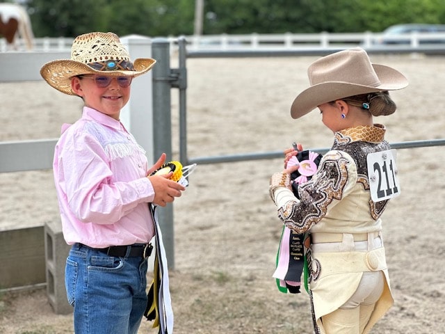little girls at wmaha community show ring holding winning ribbons smiling